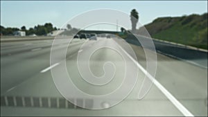 Driving on intercity freeway in Los Angeles, California USA. Defocused view from car thru glass windshield on busy