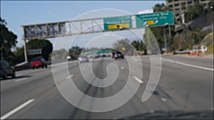 Driving on intercity freeway in Los Angeles, California USA. Defocused view from car thru glass windshield on busy