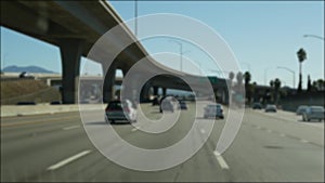 Driving on intercity freeway in Los Angeles, California USA. Defocused view from car thru glass windshield on busy interstate