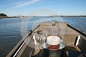 Driving jon boat on saltwater to go pick oysters in Charleston South Carolina photo