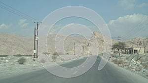 Driving by mountain road along power line poles, abandoned roadside cafe with distant blue cloudy sky. Slog 2 profile