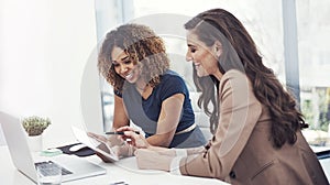 Driving productivity in business is a team effort. two businesswomen using a digital tablet together during a