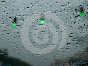 Driving in the rain on a grey nasty day on green traffic light