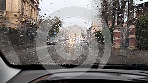 Driving in the rain view from inside car with rain drops on car windshield. Rain drops on window car windshield