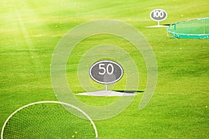 Driving range at golf course with yard signs