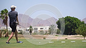 Driving Range Golf. Man practicing with golf club. Slow motion