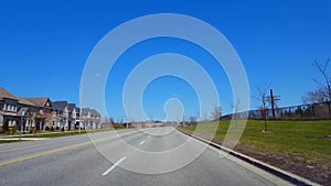 Driving residential road during spring day. driver point of view pov along beautiful sunny street