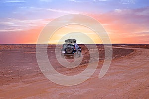 Driving through the Sahara desert in Morocco at sunset