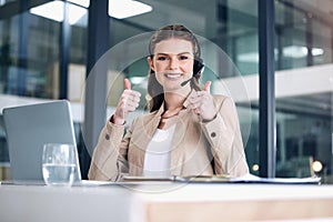 Driving sales with her friendly manner and knowledgeable mind. Portrait of a young call centre agent showing thumbs up