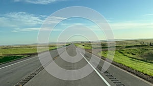 Driving in the South Dakota countryside with farm land on both sides of the road