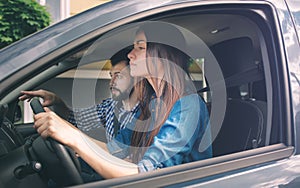 Driving test. Young serious woman driving car feeling inexperienced, looking nervous at the road traffic for information