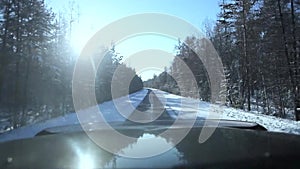 Driving through the winter forest on snowy road