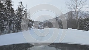 Driving through the winter forest on snowy road