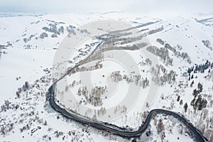 Driving on winter roads trough forest winding road in the mountains