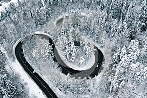 Driving on winter roads trough a forest winding road in the mountains