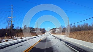 Driving Winter Rural Road in Day. Countryside Street With Snow in Daytime