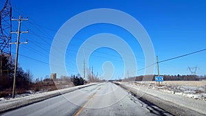 Driving Winter Rural Road in Day. Countryside Street With Snow in Daytime