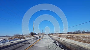 Driving Winter Rural Road in Day. Countryside Street With Snow in Daytime