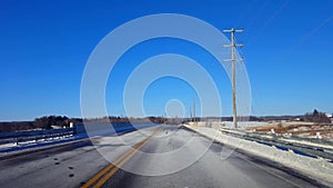 Driving winter rural road in day. Driver point of view POV countryside street with snow