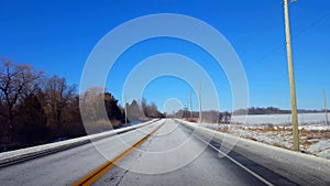 Driving winter rural road in day. Driver point of view POV countryside street with snow