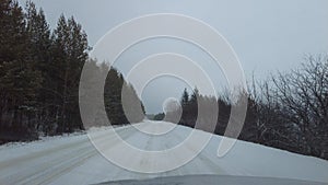 Driving winter snow road. View through the windshield on the highway in winter