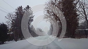 Driving Winter Snow Storm on in Residential Suburb in Day.  Driver Point of View POV Snowing Blizzard Snowfall