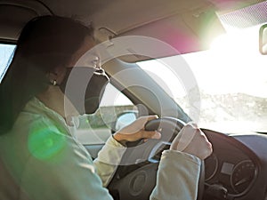 Driving woman with protective mask