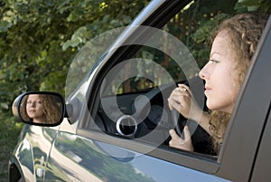 Driving woman reflecting in rear mirror