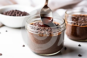 drizzling chocolate syrup on chia seed pudding