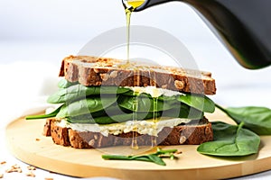 drizzling olive oil on open tempeh sandwich