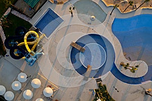 Drone aerial of empty swimming pool and water park. Deserted holiday resort hotel backyard top view