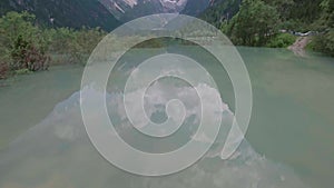Drone aerial flying over a beautiful mountain lake Landro in Dolomites Alps