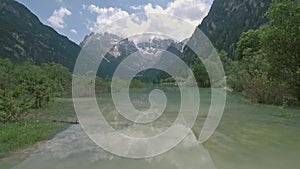 Drone aerial flying over a beautiful mountain lake Landro in Dolomites Alps