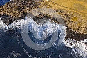 Drone aerial photograph of the ocean crashing against rocks in Kiama
