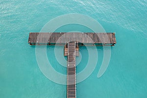 Drone aerial of pier in the ocean. Empty dock blue turquoise ocean water