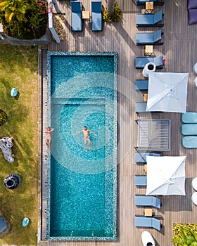 Drone aerial view from abotve at pool,Praslin Seychelles,couple men and women in pool during vacation at a luxury resort