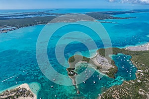 Drone aerial view of anchored sailing yacht in emerald Caribbean sea, Stocking Island, Great Exuma, Bahamas.