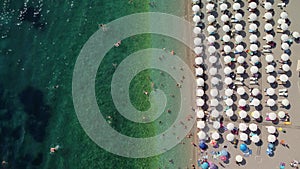 Drone aerial view of a beach filled with people on a hot summer day. High holiday season.