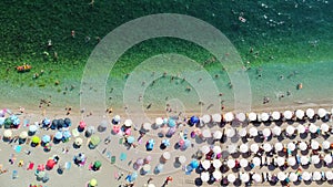 Drone aerial view of a beach filled with people on a hot summer day. High holiday season