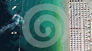 Drone aerial view of a beach filled with people on a hot summer day. High holiday season.