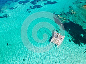 Drone aerial view of catamaran sailing boat in Maddalena Archipelago, Sardinia, Italy.