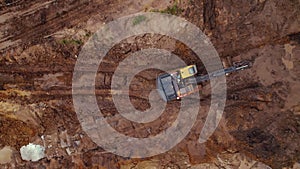 Drone aerial view of a construction machine working on a muddy building field. New expressway in the making.