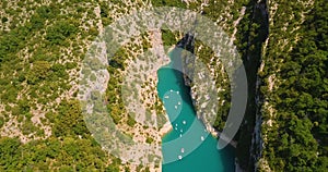 Drone aerial view of huge canyon with river in the middle with small boats adventuring photo