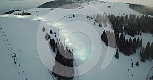 Drone aerial view of the illuminated ski slope for night skiing. Monte Pora ski resort