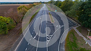 Drone aerial view new asphalt road in autumn on cloudy day, road markings