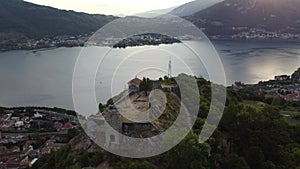 Drone aerial view of an old ruined medieval castle and the beautiful panorama of Lake Como at sunset