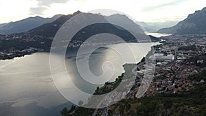 Drone aerial view of an old ruined medieval castle and the beautiful panorama of Lake Como at sunset