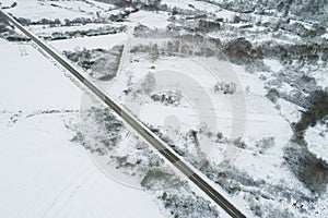 Drone aerial view of a road in a snow-covered landscape, winter time concept