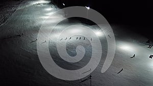 Drone aerial view of skiers on the slope, night skiing at Monte Pora ski resort