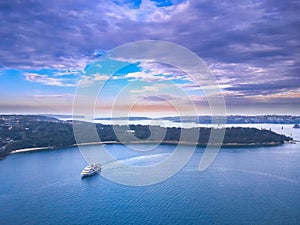 Drone Aerial view of Sydney Harbour Sydney CBD NSW Australia. cloudy dark skies, clear turquoise waters.